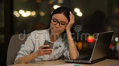懒惰的女人在工作场所使用手机，逃避无聊的工作，分心